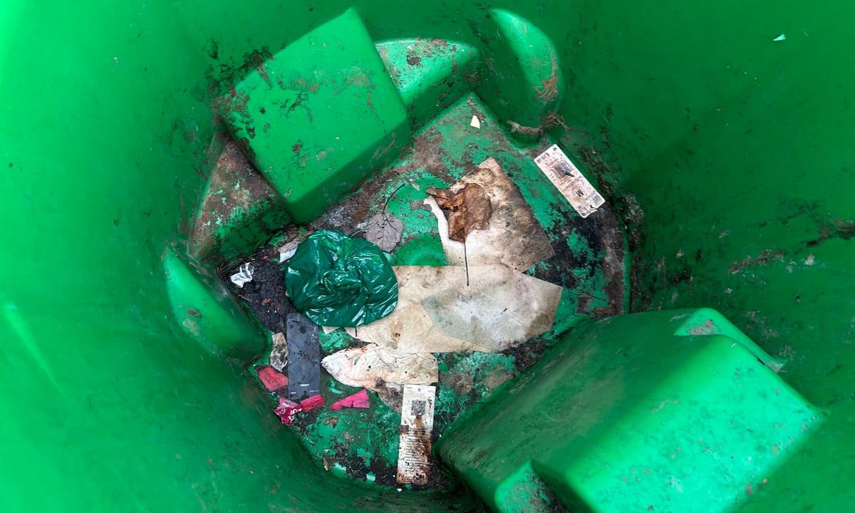 Inside of a household trash bin caked with residue before cleaning by Bin Odor Blasters