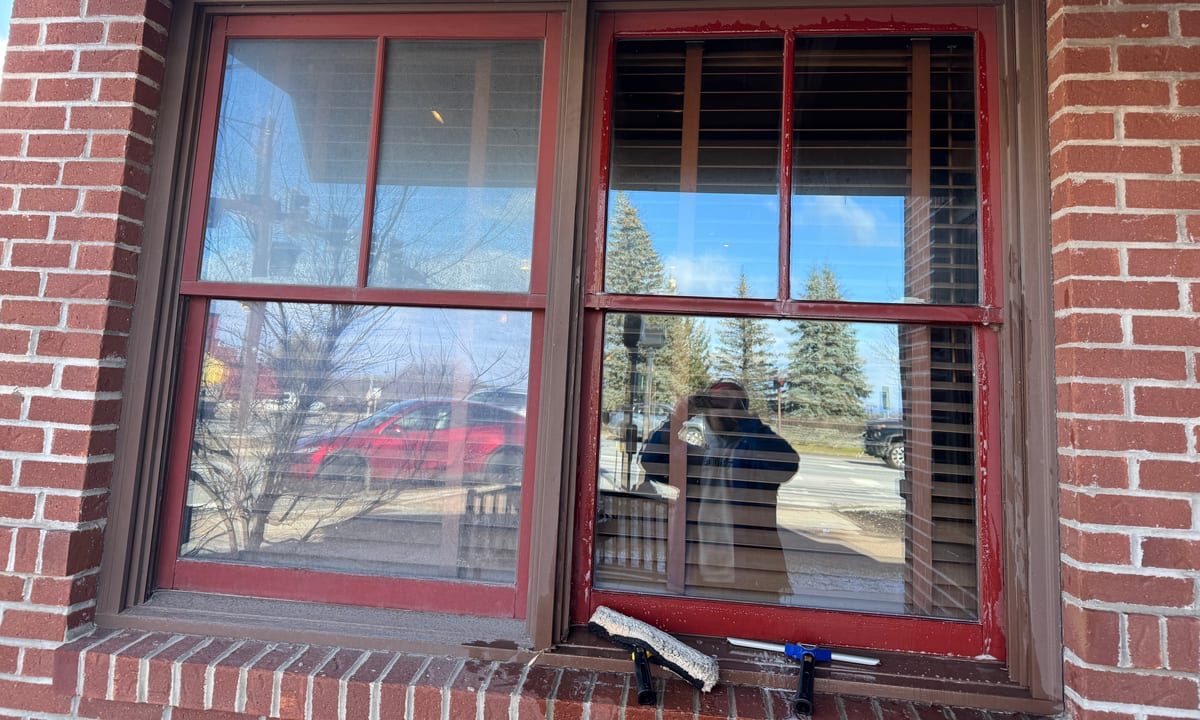 Red-framed storefront windows cleaned by Stone Window Cleaning on a brick building in Vermont